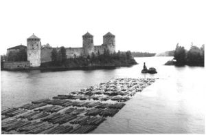 Kaukaan hinaaja vetämässä tukkilauttaa Kyrönsalmen virtaa alaspäin kesäkuussa 1961. Taustalla Olavinlinna.