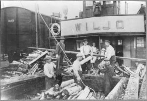 Tervahöyry s/s Wiljo (kotipaikka Savonlinna) ja osa miehistöstä purkamassa halkolastia 1920-luvulla. J-kirjaimen kohdalla (koppalakkinen) kippari Onni Vänttinen.