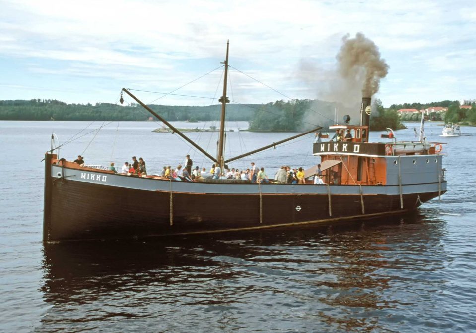 Mikko-laiva purjehtii Savonlinnan kaupungin lähivesillä. Kuvassa Mikko-laiva purjehtii Savonlinnan kaupungin vesiä. Taustalla näkyy Pihlajavesi ja osa kaupunkia.